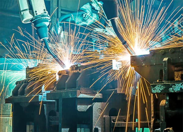 Two robotic welders in the process of welding.